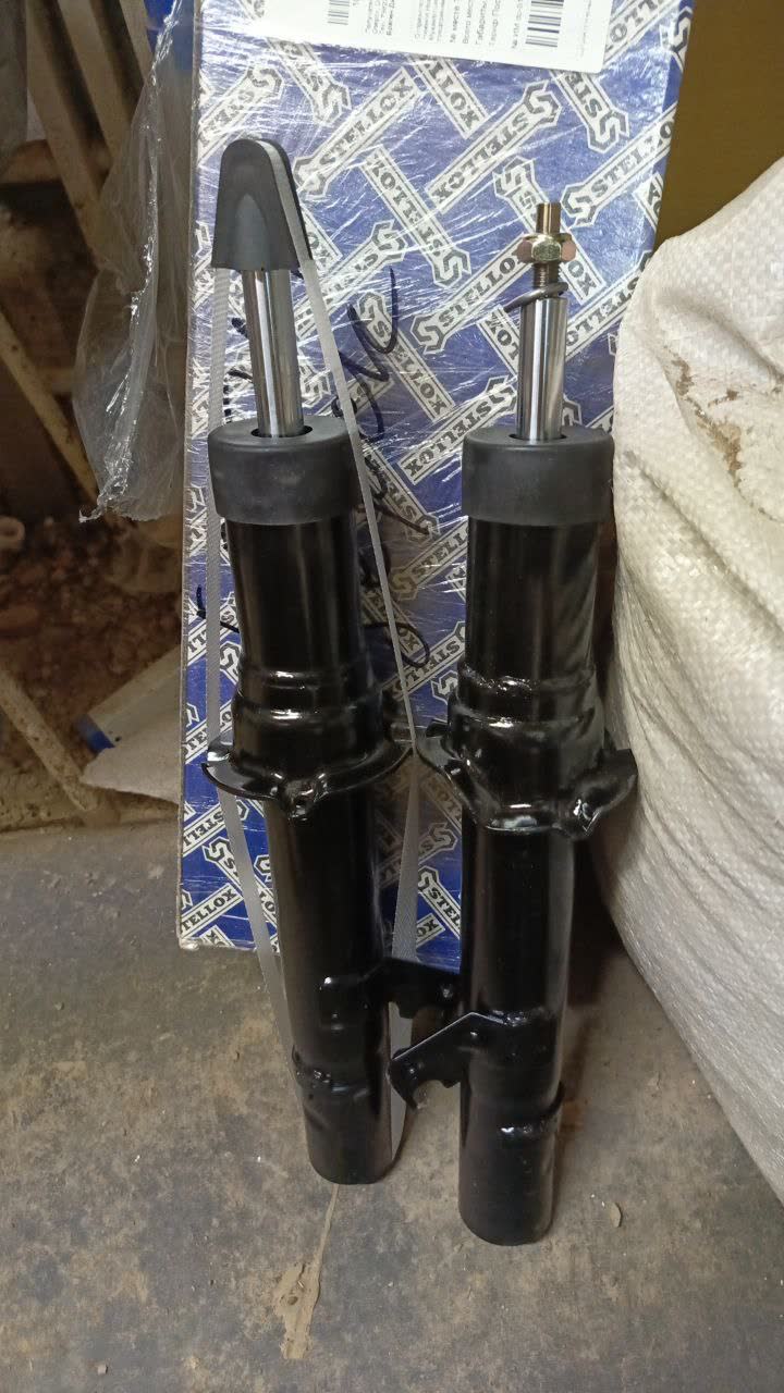 Pair of shock absorbers showing one with factory barcode label, one without