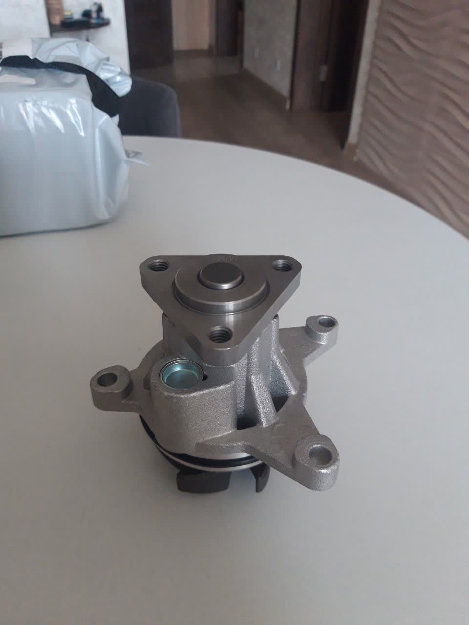 Comparison photo of the mounting-hole spacing on the received pump versus the original