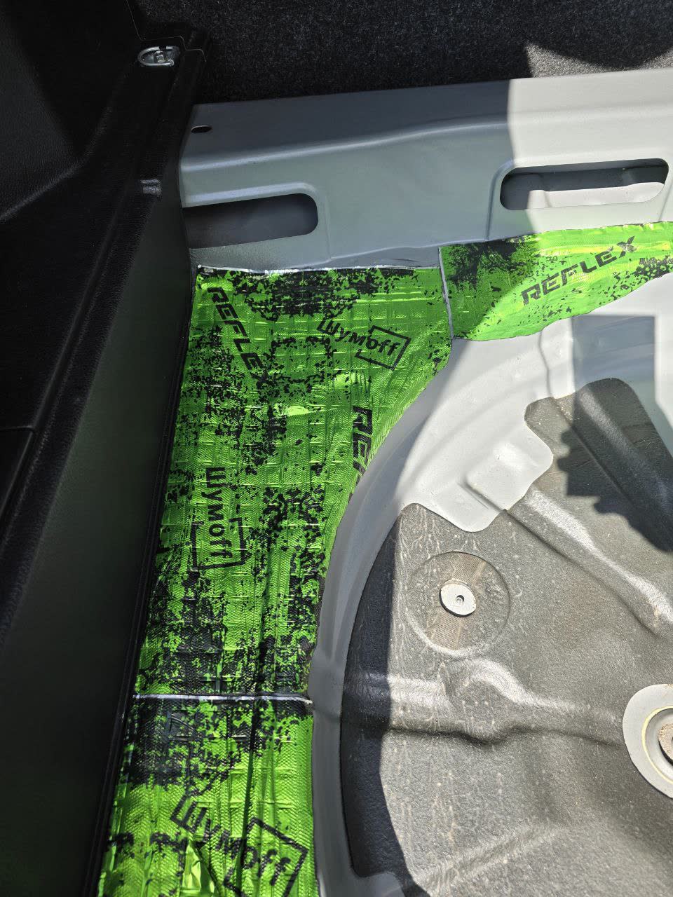 Photo showing sound-insulation material layers applied to door and floor panels