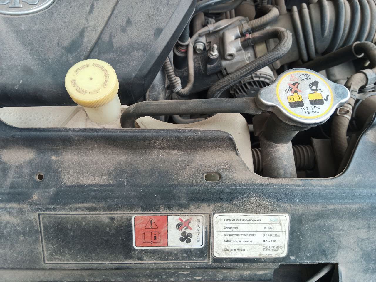 Cooling-system expansion tank/radiator cap photo showing the 127 kPa (18 psi) pressure specification